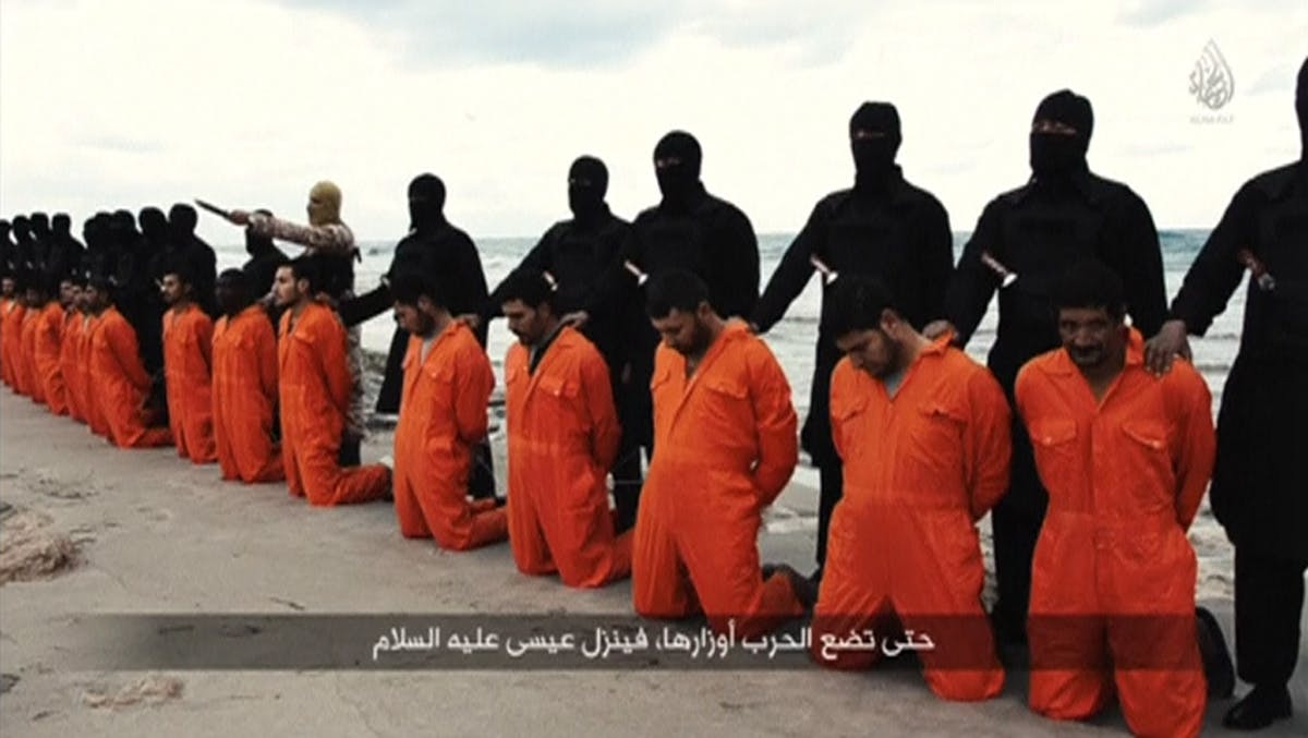 Still image from video shows men purported to be Egyptian Christians held captive by the Islamic State kneeling in front of armed men along a beach said to be near Tripoli