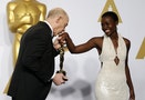 Simmons, winner of the award for best supporting actor nominee for his role in "Whiplash," kisses the hand of presenter Lupita Nyong'o during the 87th Academy Awards in Hollywood
