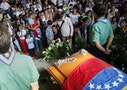 People stand in front of the coffin of Kluiver Roa during his funeral in San Cristobal
