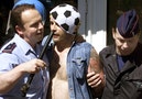 A Belgian policeman arrests a German soccer fan wearing a soccer ball on his head in Charleroi's mai..