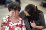 一位老太太為李光耀去世而哭泣，一位中央醫院的護士在旁安慰她。AP 達志影像。