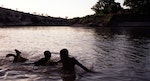 歐莫河裡抱著水桶戲水的卡羅少年
