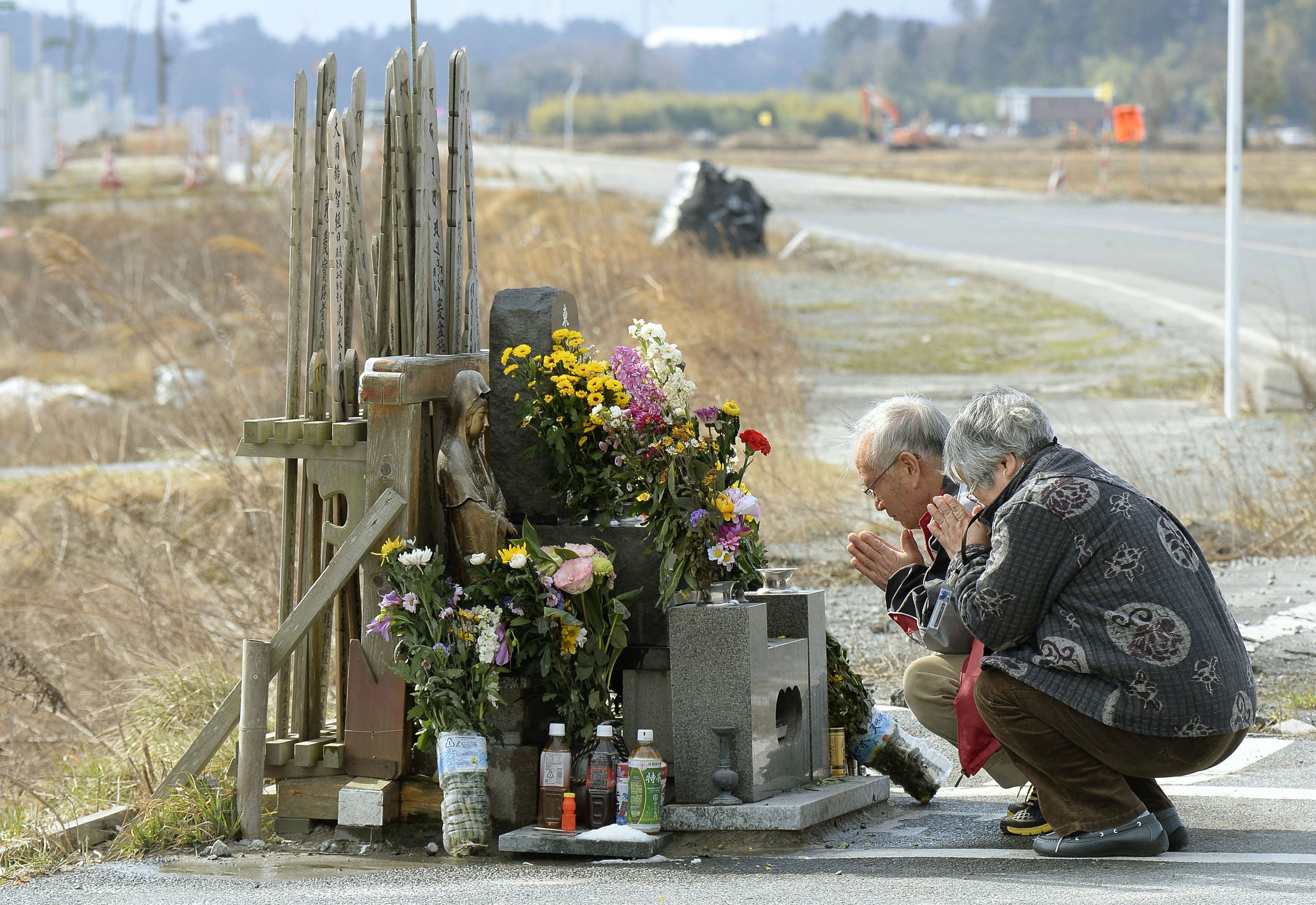 People pray for victims of the March 11, 2011 earthquake and tsunami near TEPCO's tsunami-crippled Fukushima Daiichi nuclear power plant at Namie town