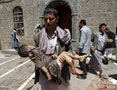 A man carries the body of a child out of the mosque which was attacked by a suicide bomber in Sanaa