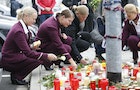 Germanwings employees cry as they place flowers and lit candles outside the company headquarters in Cologne Bonn airport