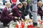 Germanwings employees cry as they place flowers and lit candles outside the company headquarters in Cologne Bonn airport