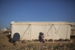 一位敘利亞婦女抱著女兒，沉默的坐在帳外。 Photo Credit : AP/達志影像