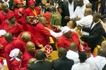 Members of Julius Malema's Economic Freedom Fighters (EFF) (in red) clash with security officials after being ordered out of the chamber during President Jacob Zuma's State of the Nation address in Cape Town
