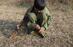 15歲的果敢民主民族同盟軍的童兵，他拾起子彈，把子彈一顆顆的裝入來福槍中。Photo Credit: Reuters/達志影像