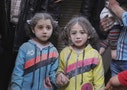Girls who survived what activists said was a ground-to-ground missile attack by forces of Syria's President Assad, hold hands at Aleppo's Bab al-Hadeed district
