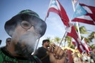 A demonstrator smokes a marijuana cigarette during a protest outside the Capitol building in San Juan