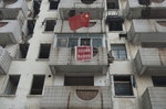 Xu Aiguo, the owner of a nail house, the last house in the area, set up a Chinese national flag outside his balcony in Nanjing, Jiangsu province