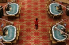 Employee walks past tables at SJM's flagship casino Grand Lisboa in Macau