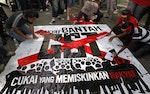 Labour activists sign on a banner reading "People Against GST (Goods and Services Tax)" during a May Day rally in Kuala Lumpur