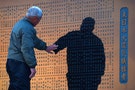 A fisherman touches the name of a fellow fisherman killed by the March 11, 2011 earthquake and tsunami, at a cenotaph in Sendai