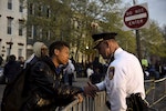 Ninth-grader Tremaine Holmes shakes hands with Captain Erik Pecha in front of the Baltimore Police Department Western District station during a protest against the death in police custody of Freddie Gray in Baltimore