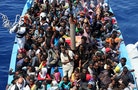 A group of 300 sub-Saharan Africans sit in board a boat during a rescue operation by the Italian Finance Police vessel Di Bartolo off the coast of Sicily