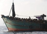Migrants are seen aboard a boat tethered to a Thai navy vessel, in waters near Koh Lipe island