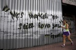 「我們依然愛你」一位女性慢跑過一面塗有「希臘：梅克爾我們依然愛你」的鐵皮牆面。希臘總理齊普拉斯6月27日針對國外債權人撙節方案的提議交付全民公投。他拒絕貸款人的「最後通牒」，並將希臘的未來交由全民決定。Photo Credit: Reuters/達志影像