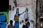 【除了危機外還有什麼？】 一名男子走過希臘街頭畫家Bleeps在雅典塗鴉作品。在過去五年裡，希臘經濟蕭條，民不聊生，越來越多的街頭塗鴉對希臘的財政和社會危機發表評論。Photo Credit: AP/達志影像