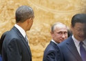 Putin looks back at Obama as they arrive with Xi Jinping at APEC Summit plenary session in Beijing