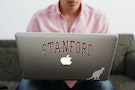 Chris Barber, a student at Stanford University, uses a laptop computer as he conducts business in his dorm room in Stanford