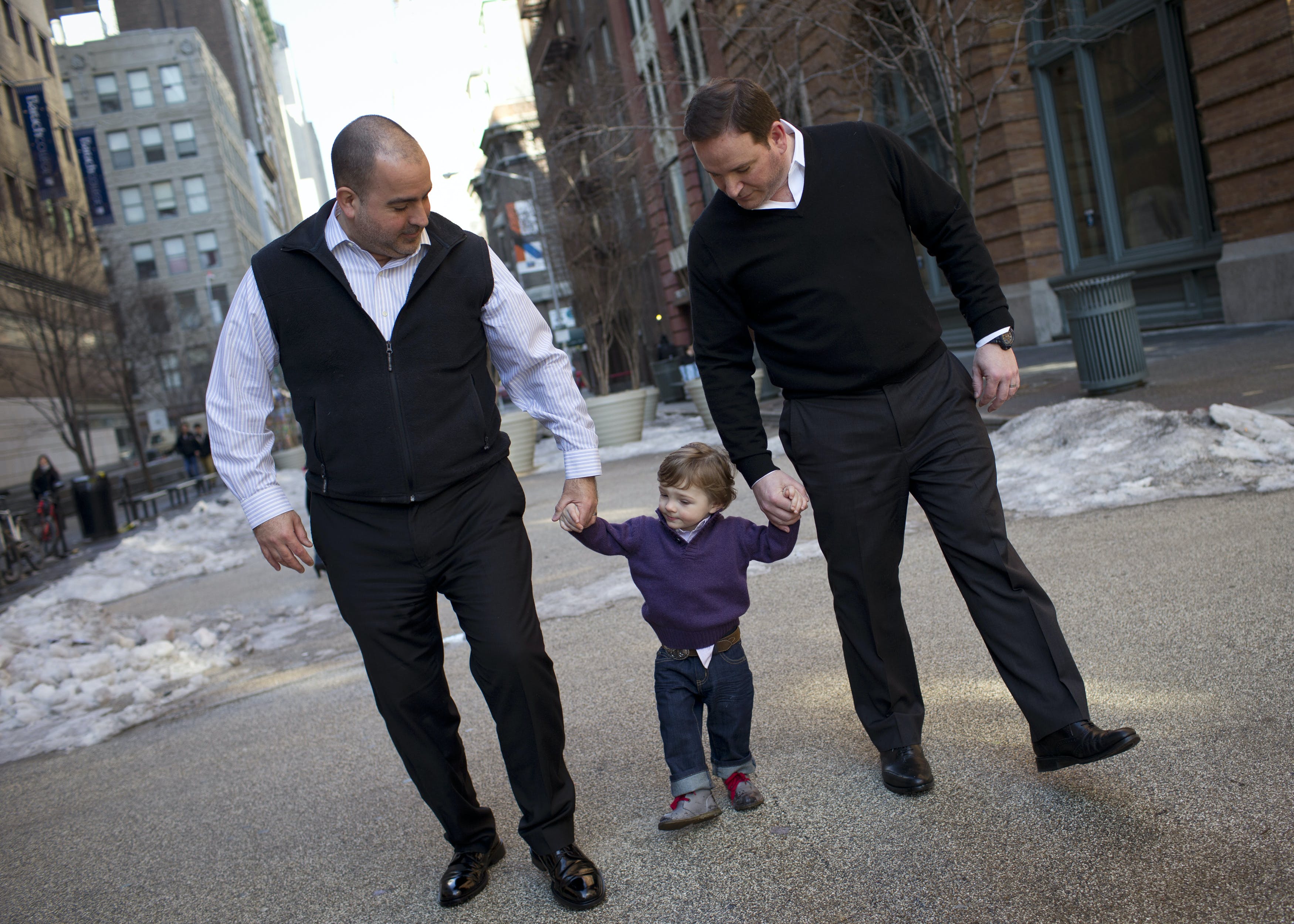 Joseph Vitale and his husband Robert Talmas walk with their adopted son Cooper near their New York City apartment