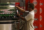 A worker of PT Multi Bintang Indonesia Tbk. holds a bottle of Bintang beer to check the quality at a beer factory in Jakarta
