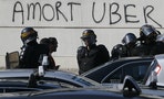 French riot police secure the Porte Maillot during a demonstration by French taxi drivers, who are on strike, to block the traffic on the Paris ring road during a national protest against car-sharing 