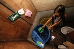 MaryJoy prepares to take a bath before going to school at home in a squatter colony in Quezon city, Manila