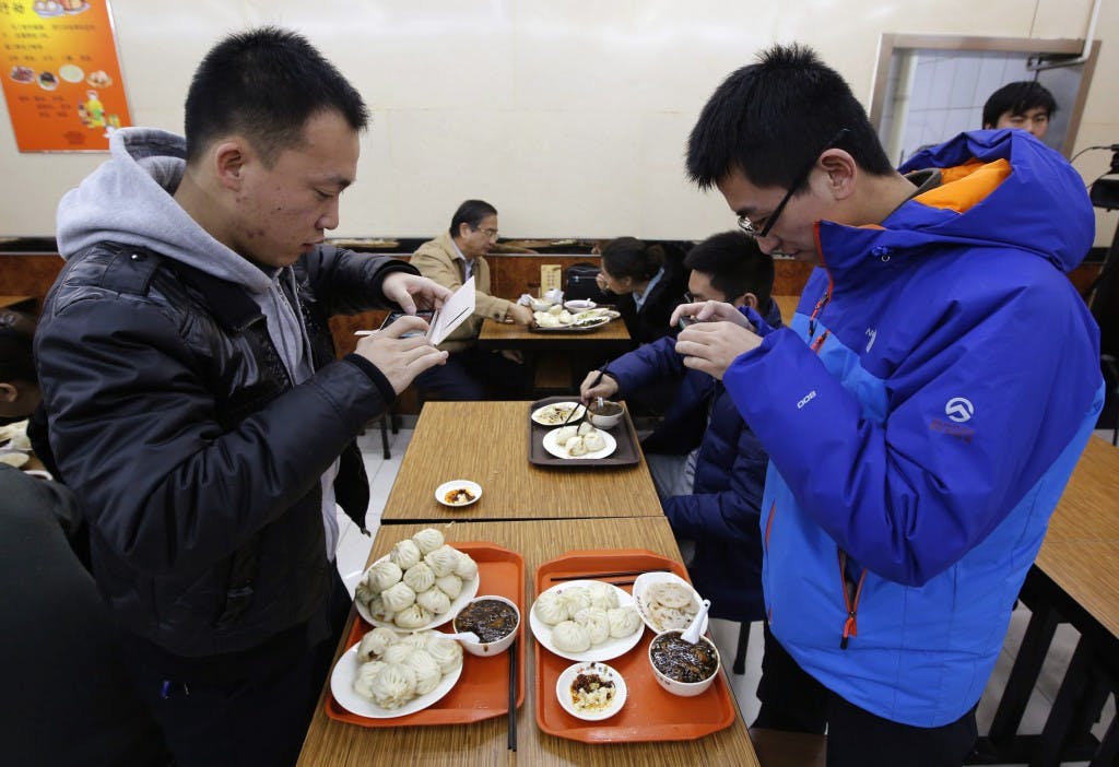 Diners take pictures of steamed buns which Chinese President Xi ate, at the Qing-Feng steamed buns restaurant in Beijing