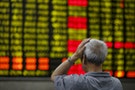 Investor looks at an electronic board showing stock information at a brokerage house in Shanghai
