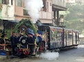 Indian railways officials stand on the front of the famed "toy train" as it runs on the two-foot wid..