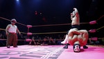Lucha libre wrestlers Matt Classic and teammate Mini Matt Classic taunt Cholitito during their fight during the Lucha VaVOOM show at the Mayan Theatre in Los Angeles