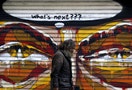 A man walks by a mural in Athens