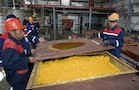 Workers close container of uranium oxide after opening of the Khorasan-1 uranium mine in southern Kazakhstan