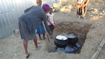 正在煮大鍋飯給孩子的婦女。