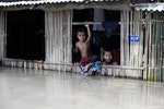 緬甸孩童從房內向外頭觀看，他們的家位於距仰光西南部60英里miles的伊洛瓦底三角洲。許多國際救援組織紛紛動員，截至8月5日，水災已造成69人死亡。 
