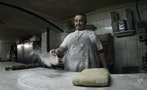 Baker Miquel Pujol pours flour over his working table at his bakery in Palma de Mallorca