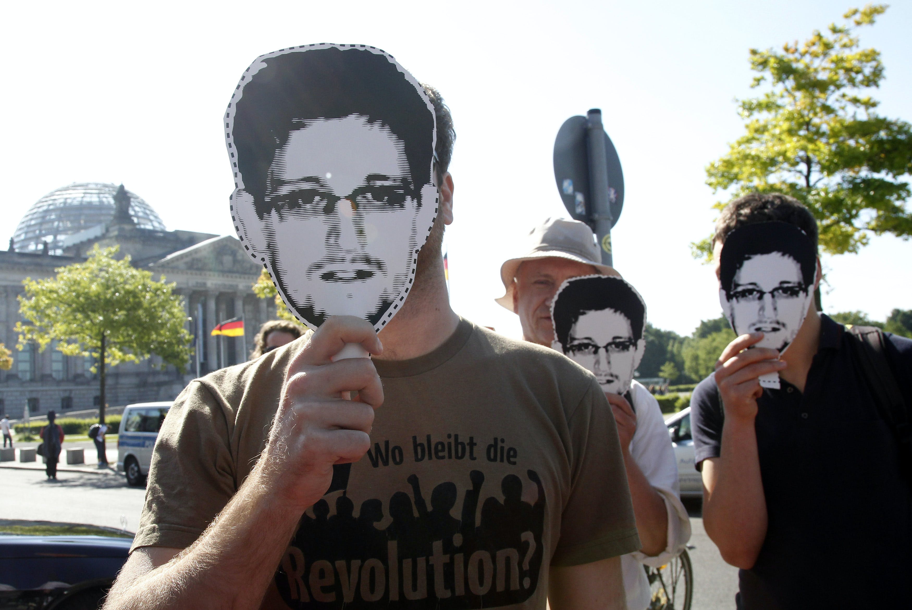 Protesters hold masks depicting former U.S. National Security Agency contractor Edward Snowden during a demonstration in Berlin