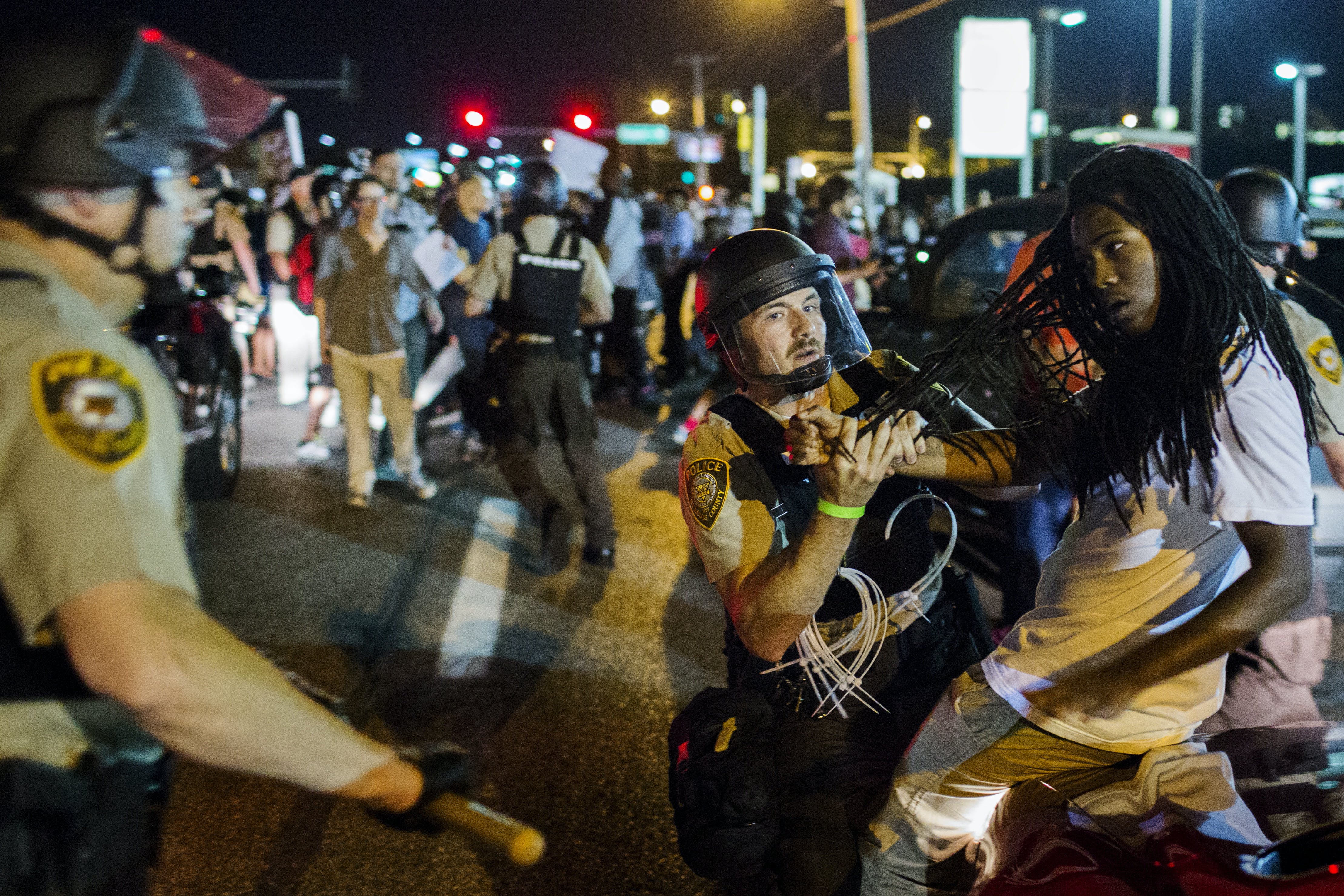 St Louis County police officers hold an anti-police demonstrator in Ferguson, Missouri
