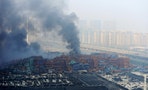 Smoke rises from shipping containers after explosions at Binhai new district in Tianjin