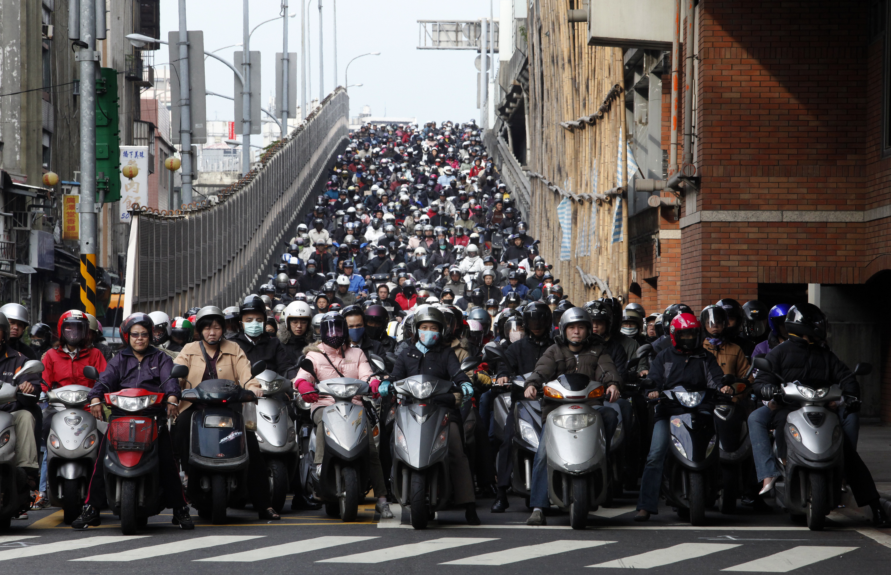 Скутер на час. Мотоциклисты на дороге в час-пик в Тайбэе. Много китайцев на мотоцикле. Толпа на скутере. Китайские мотоциклисты на улице.