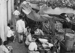 1957年初，人們在新加坡濱水區的路邊攤吃東西。