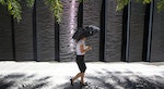 A woman walks with an umbrella during lunch in Taipei