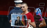A migrant holds a portrait of German Chancellor Angela Merkel after arriving to the main railway station in Munich