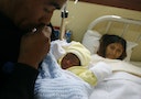 Peruvian Miriam Herrera rests as her husband holds their newborn baby at Lima's maternity hospital