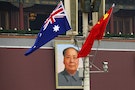 The Australian national flag flies next to the Chinese national flag in front of the giant portrait of former Chairman Mao Zedong in Beijing
