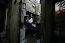 An elderly resident poses in his cubicle in Mong Kok district in Hong Kong