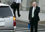 CIA Director John Brennan wipes his face as he waits for his SUV to take him from the West Wing of the White House in Washington